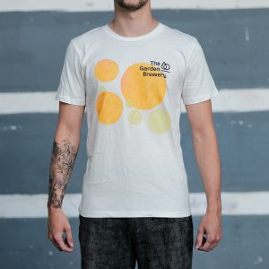 The Garden Brewery white T-shirt with yellow and green watercolour artwork and black logo on the left side of the chest.